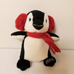 2006 black and white penguin with red scarf and ear muffs children's plush toy.